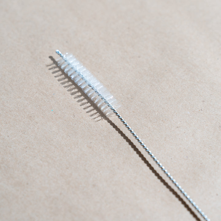 Straw cleaning brush on a paper back surface. 