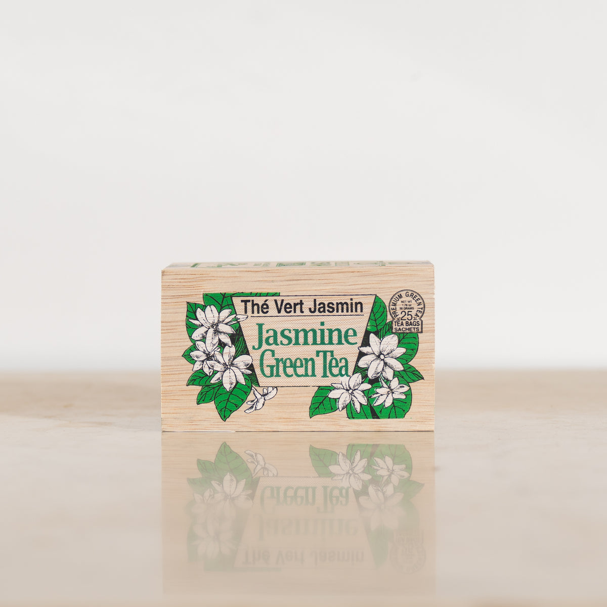 Front view of a wooden tea box with the words "Thé Vert Jasmin" and "Jasmine Green Tea" surrounded by illustrations of flowers.