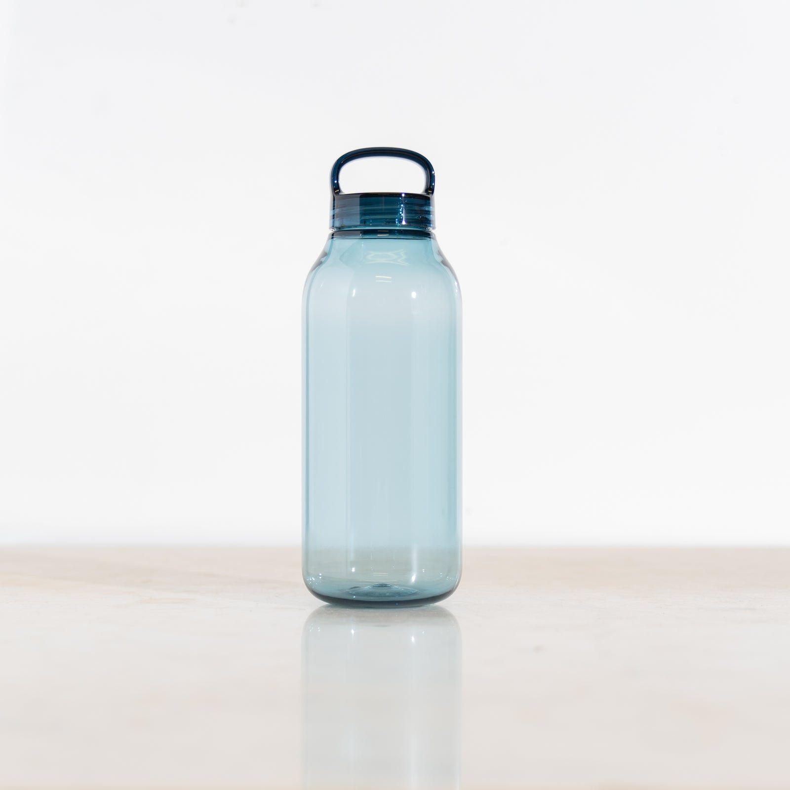 Clear blue Kinto water bottle with a dark blue cap on a white background
