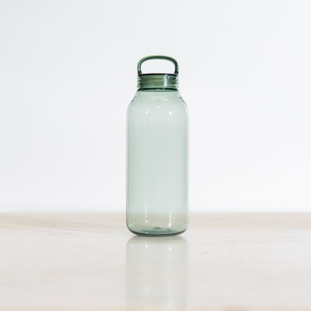 Clear green-tinted plastic water bottle with a green cap on a light background