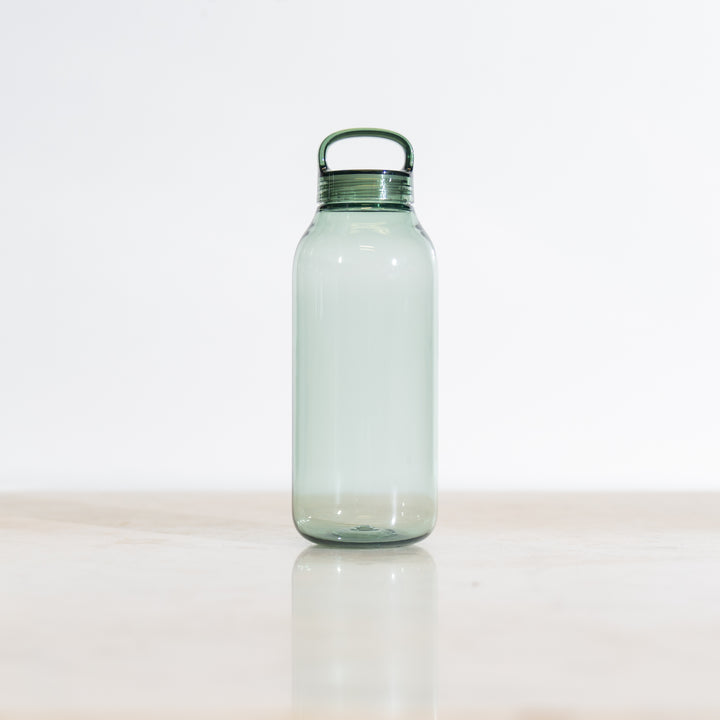 Clear green-tinted plastic water bottle with a green cap on a light background