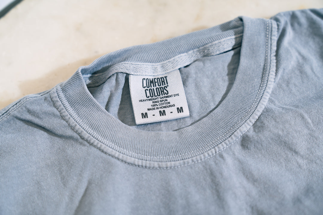 Gray t-shirt with a Comfort Colors label on a light background