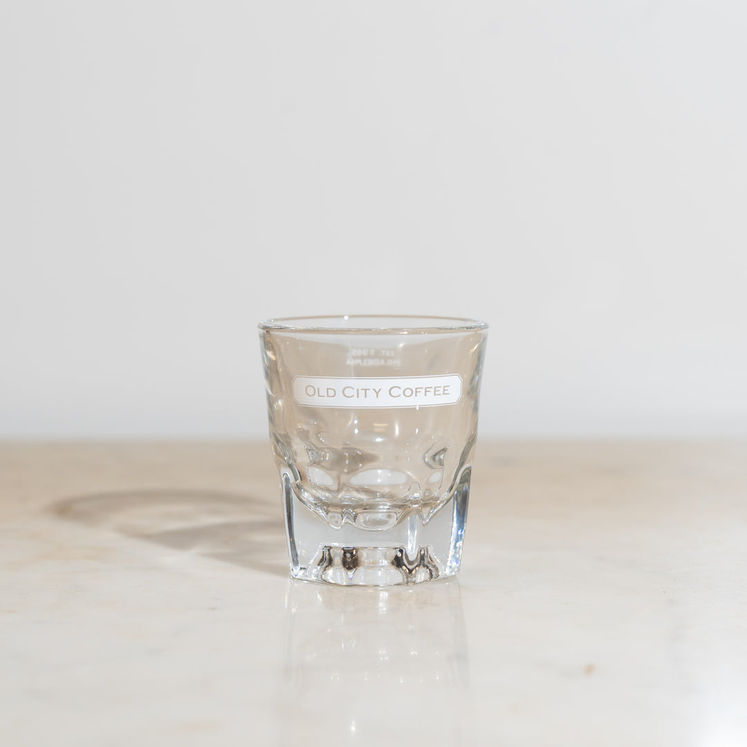 A front view of a 4oz clear Gibraltar glass featuring a white Old City Coffee logo near the rim.
