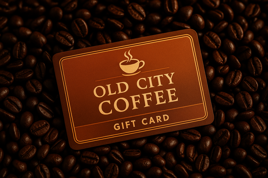 A gift card for Old City Coffee laying in a bed of coffee beans 