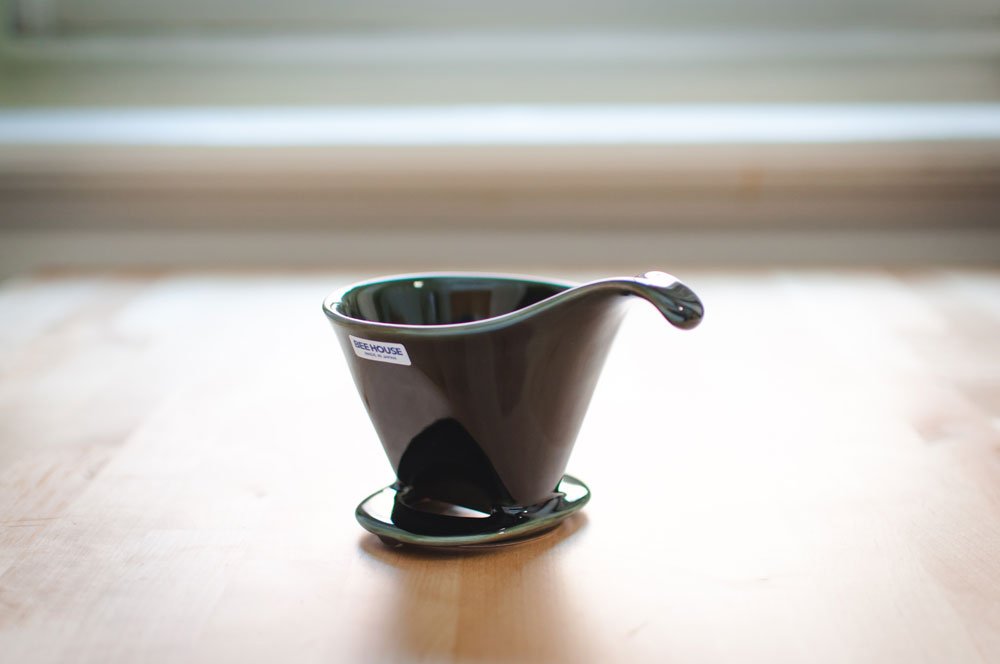 Dark green Beehouse porcelain dripper on a wooden table