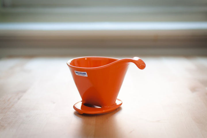Orange Beehouse porcelain dripper on a wooden table