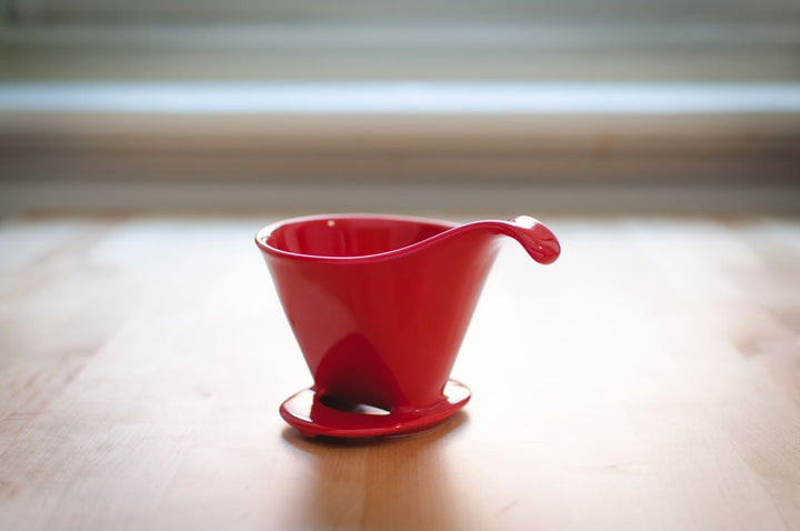 Red Beehouse porcelain dripper on a wooden table