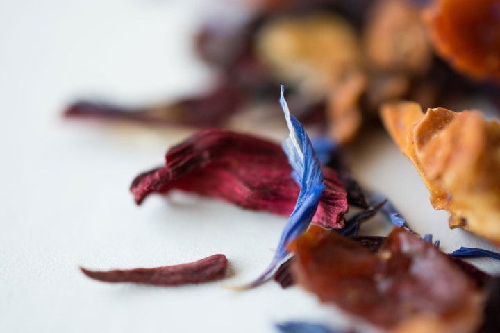 Close-up of the Blue Eyes blend showing a blue cornflower petal among dried fruit