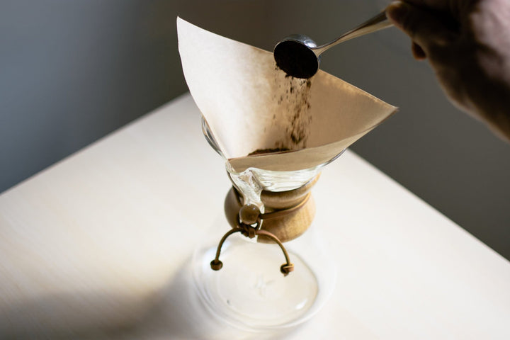 Ground coffee being poured into the Chemex paper filter