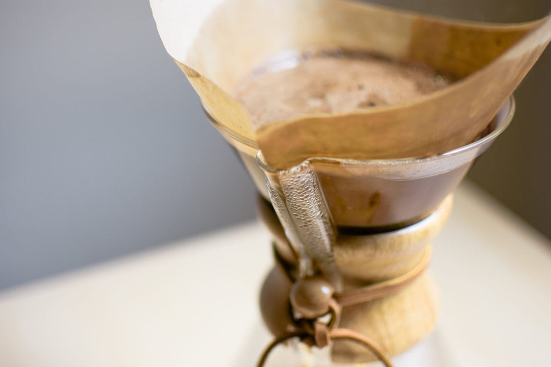 Paper filter in the Chemex filled with blooming coffee grounds