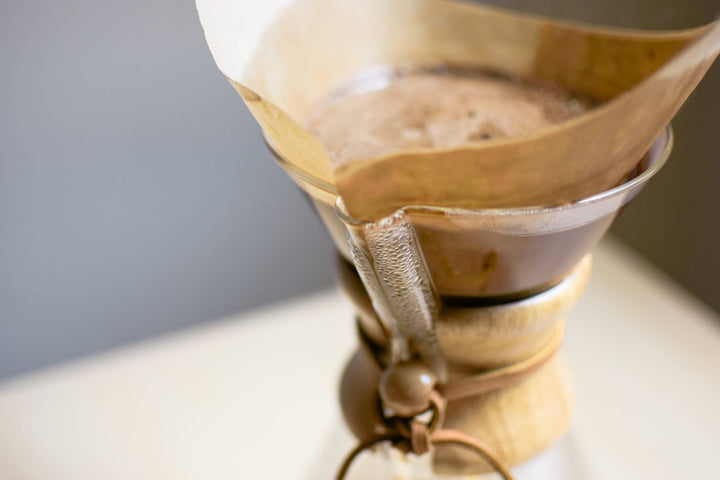 Paper filter in the Chemex filled with blooming coffee grounds