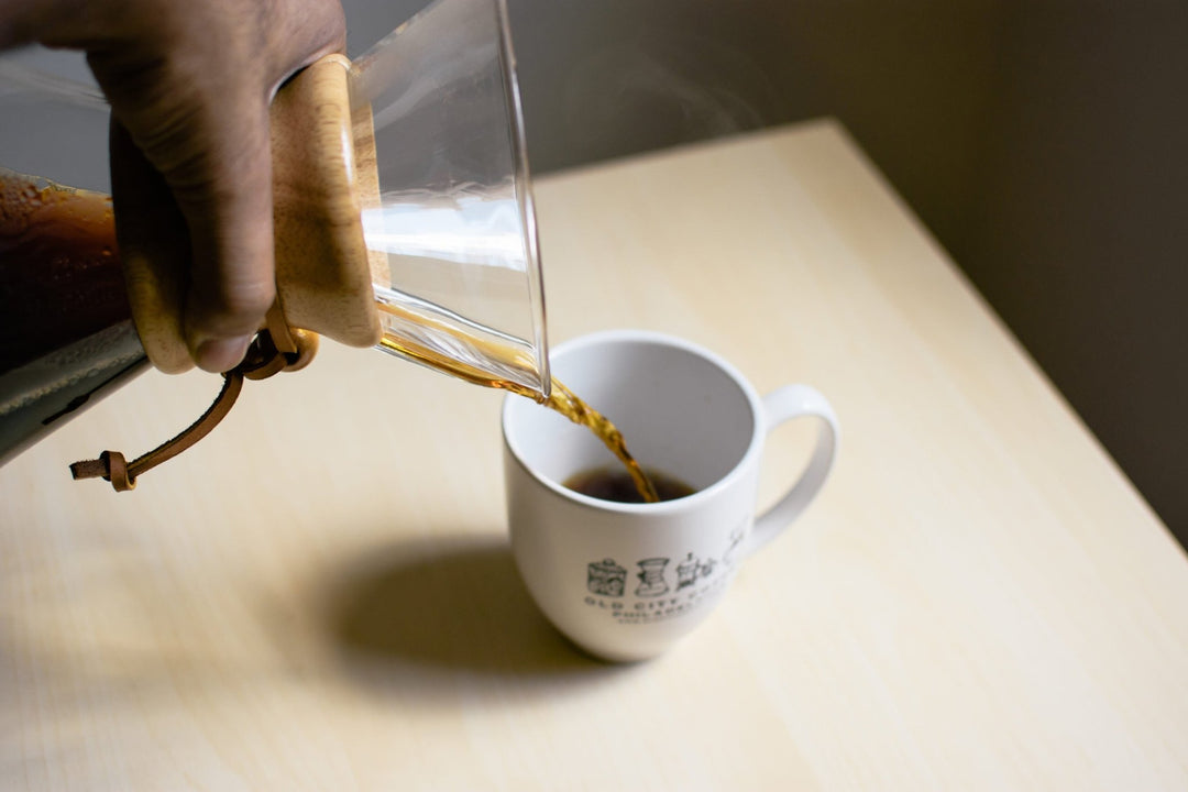 Coffee being poured from a Chemex into a white Old City Coffee mug