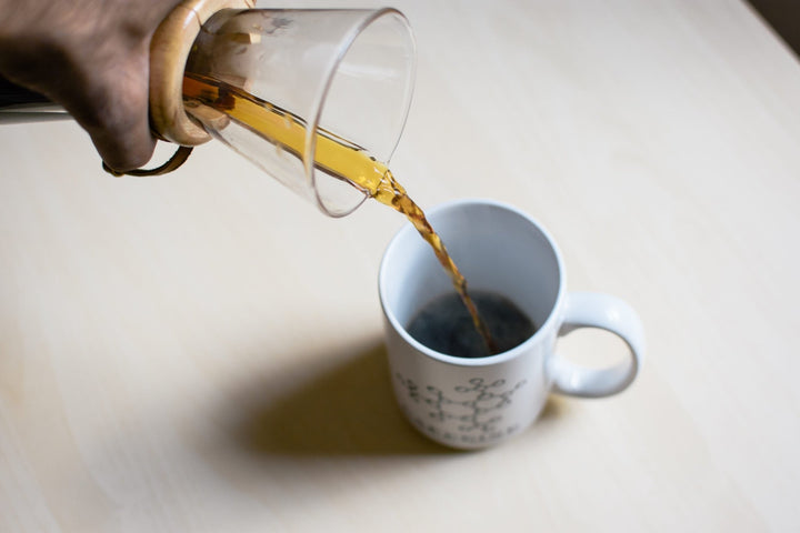 Coffee being poured from the Chemex into a white Old City Coffee mug