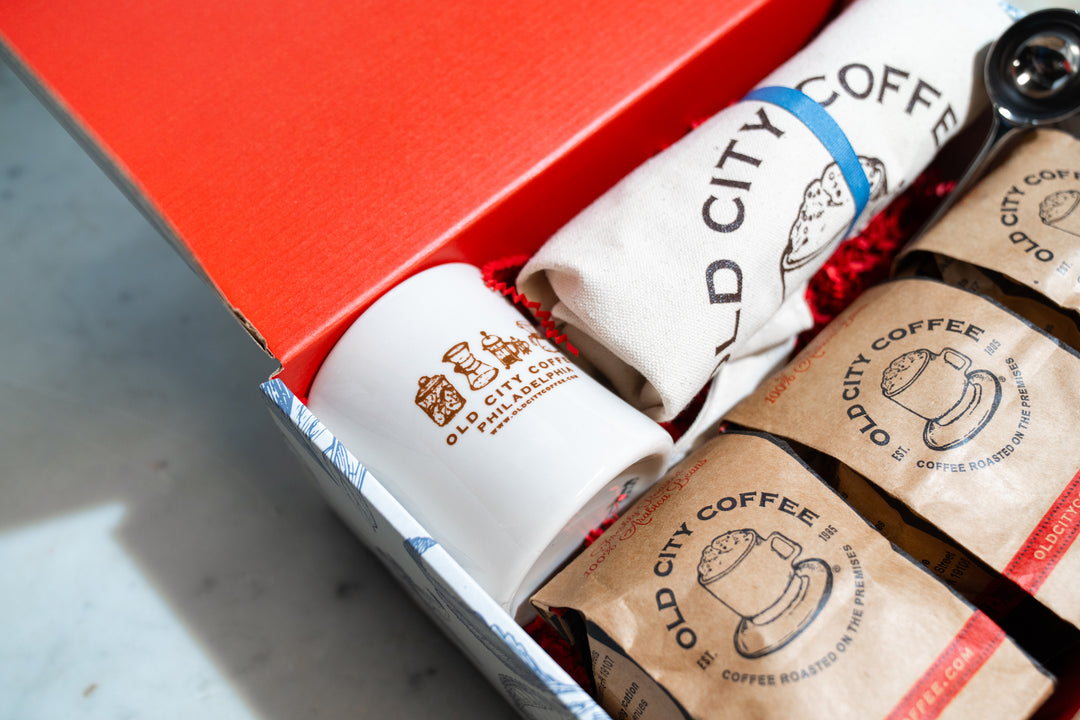 Inside the red gift box: kraft coffee bags, a rolled Old City Coffee tote, and a stainless scoop