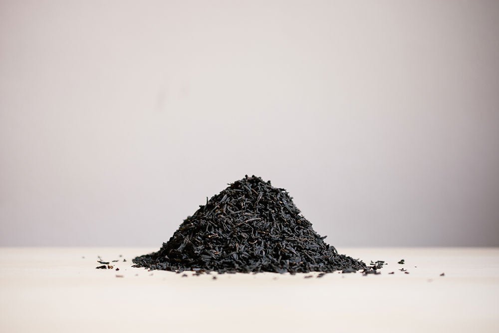 Small pile of loose Earl Grey black tea on a white surface