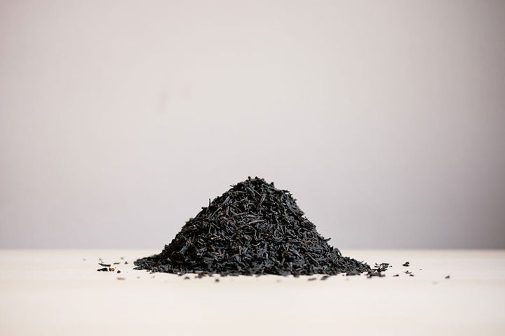 Small pile of loose Earl Grey black tea on a white surface