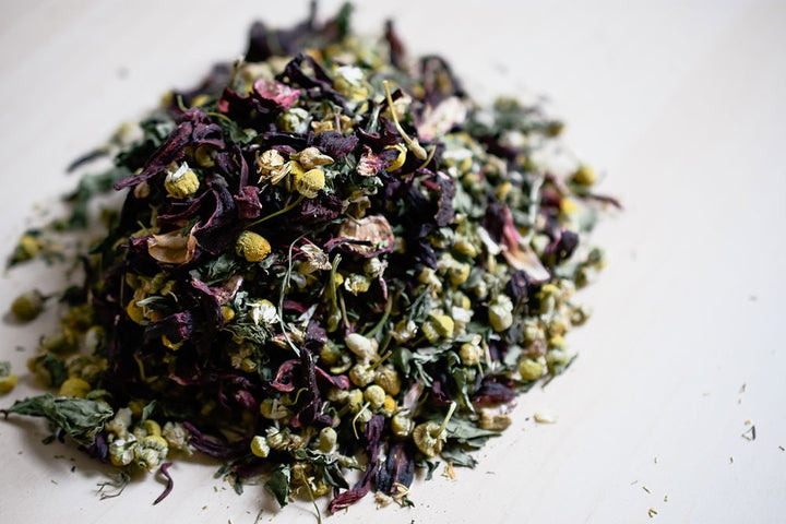 Heap of loose herbal blend showing chamomile and hibiscus