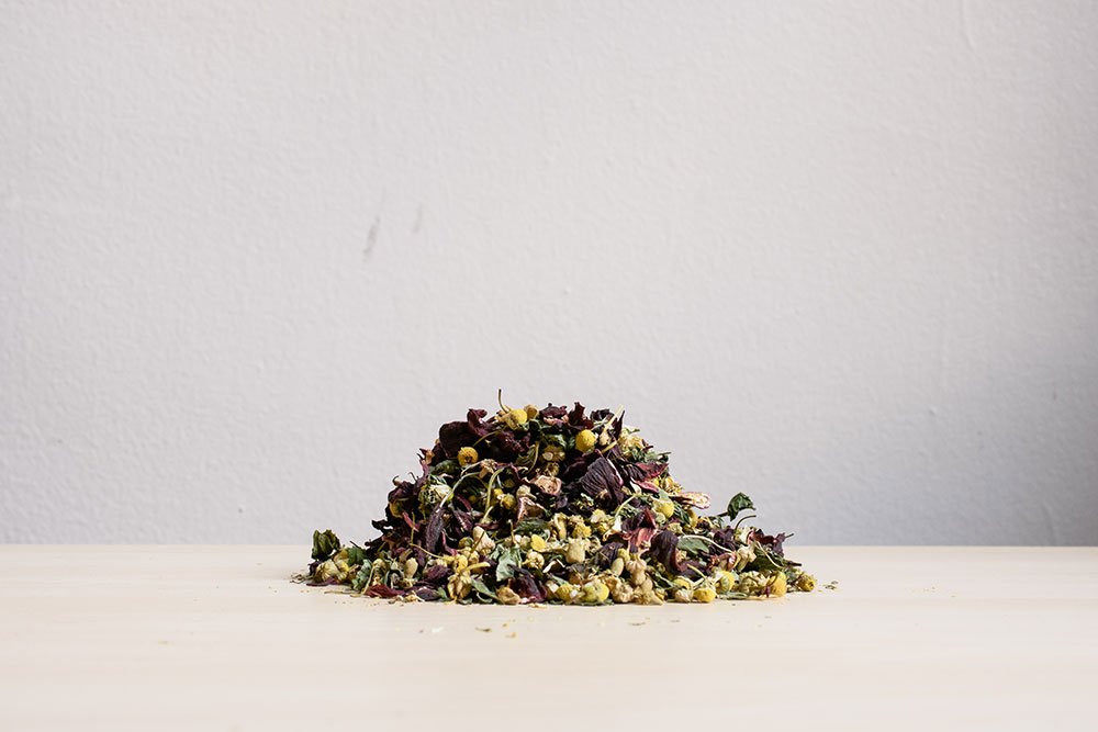 Small pile of loose herbal tea blend on a white surface