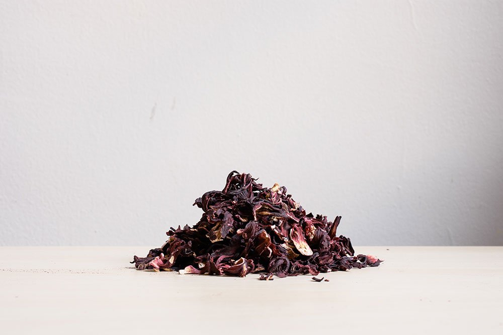 Small pile of dried hibiscus petals on a white surface