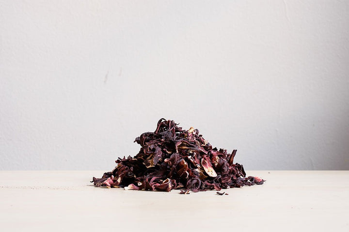 Small pile of dried hibiscus petals on a white surface