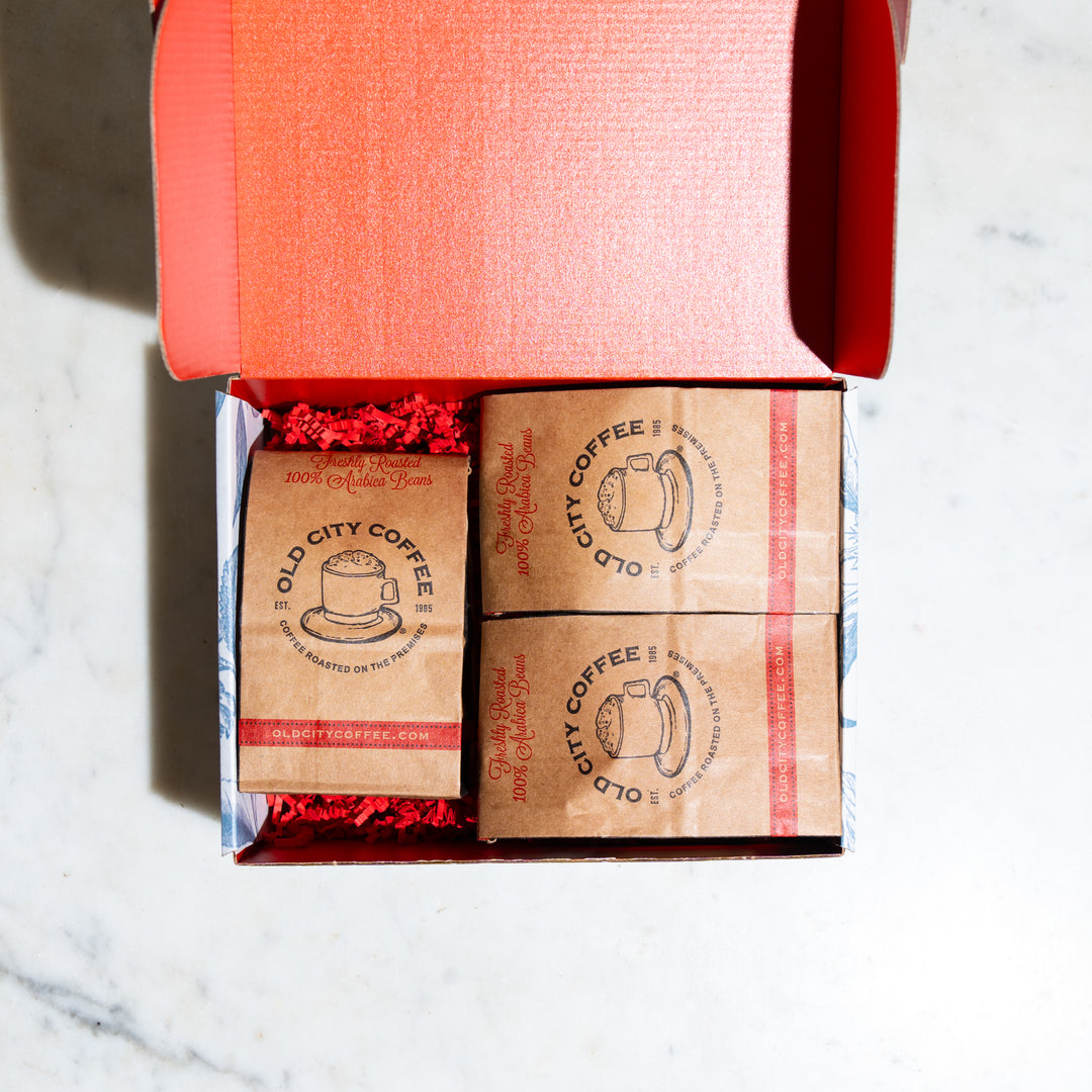 Open red gift box holding three kraft Old City Coffee bags