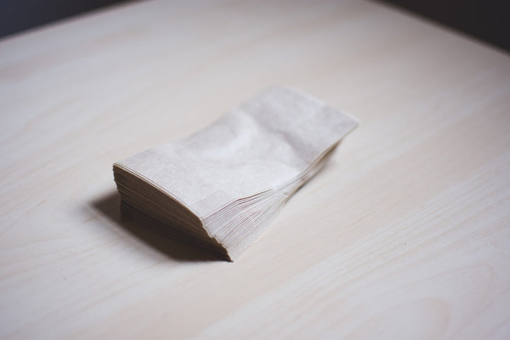 Stack of unbleached paper tea filters on a wooden table